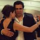Couple dancing tango passionately indoors.
