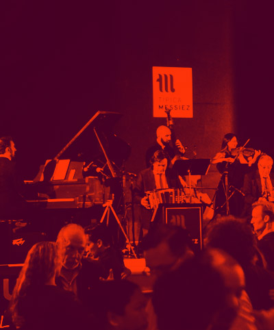 Live music performance with vibrant red lighting and enthusiastic crowd.