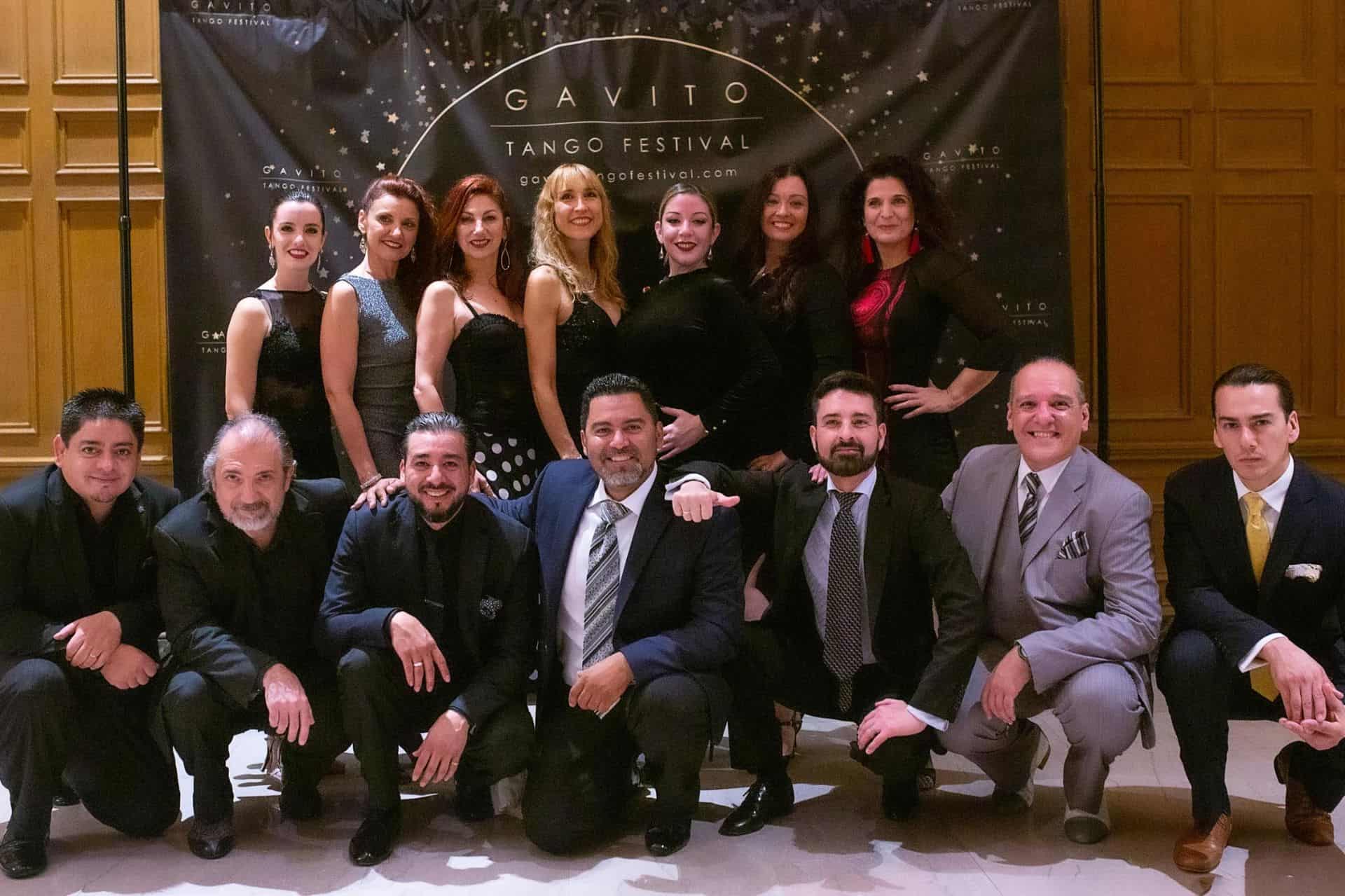 A group portrait of formally dressed individuals posing together indoors.