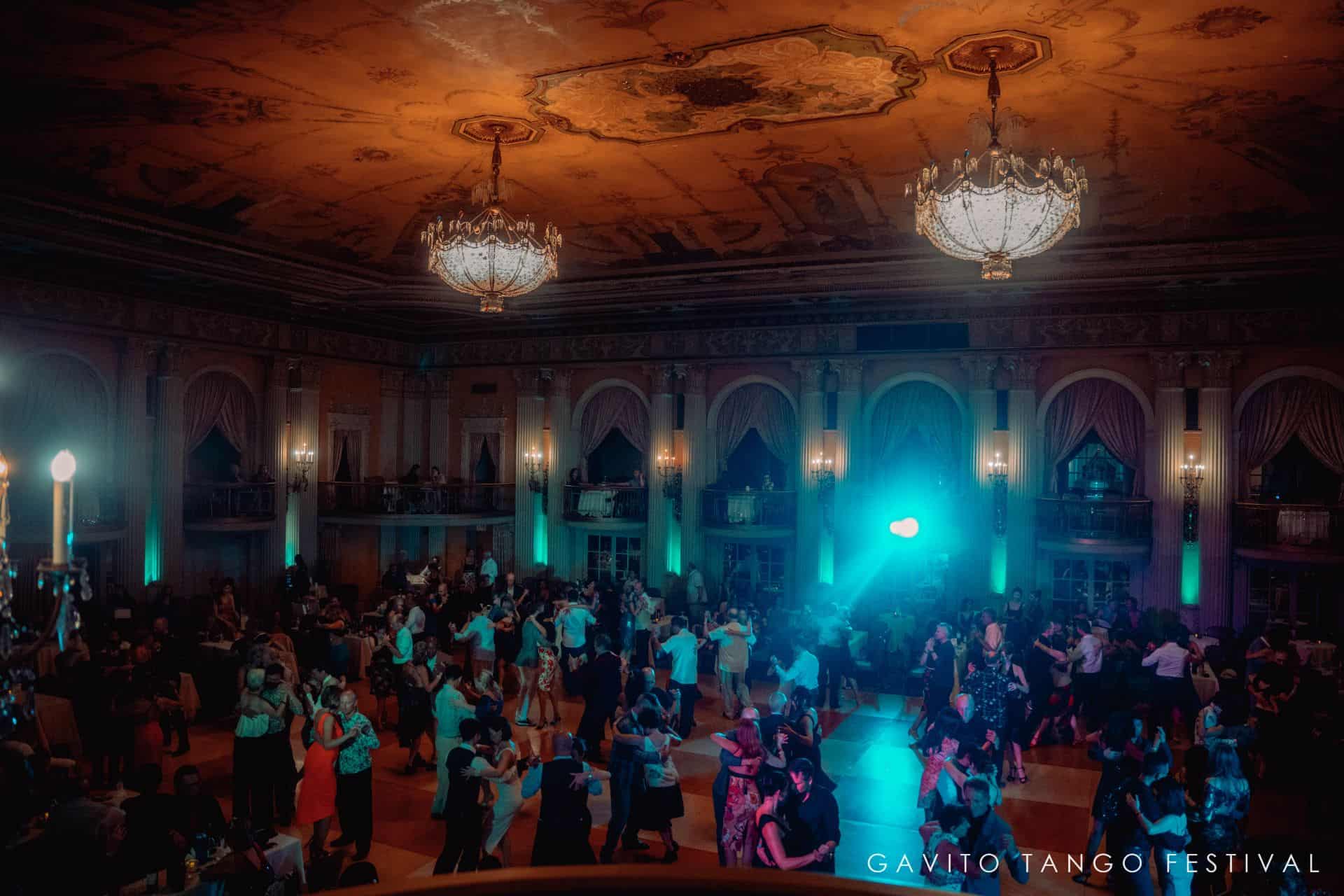 A large audience watches a stage performance in a grand theater.