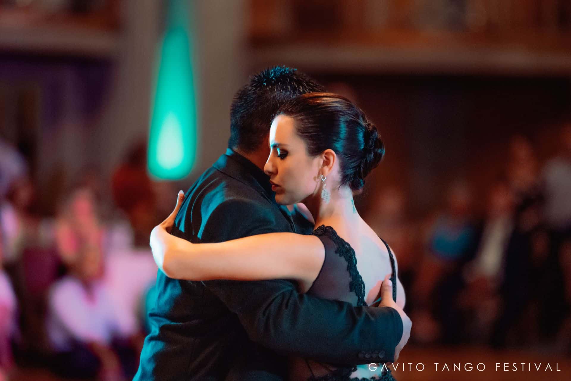 Couple embracing warmly at a dimly lit event.