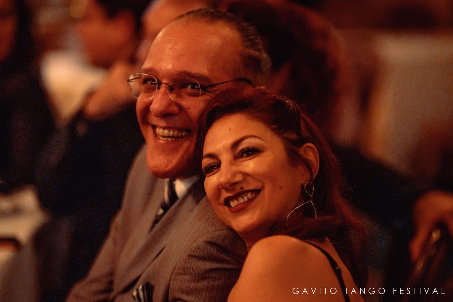 A joyful couple sharing a warm moment at a formal event.