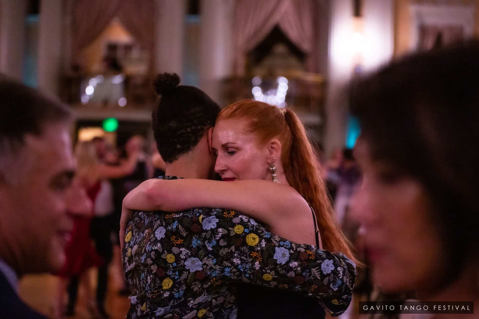 A couple dancing closely in a warmly lit room.