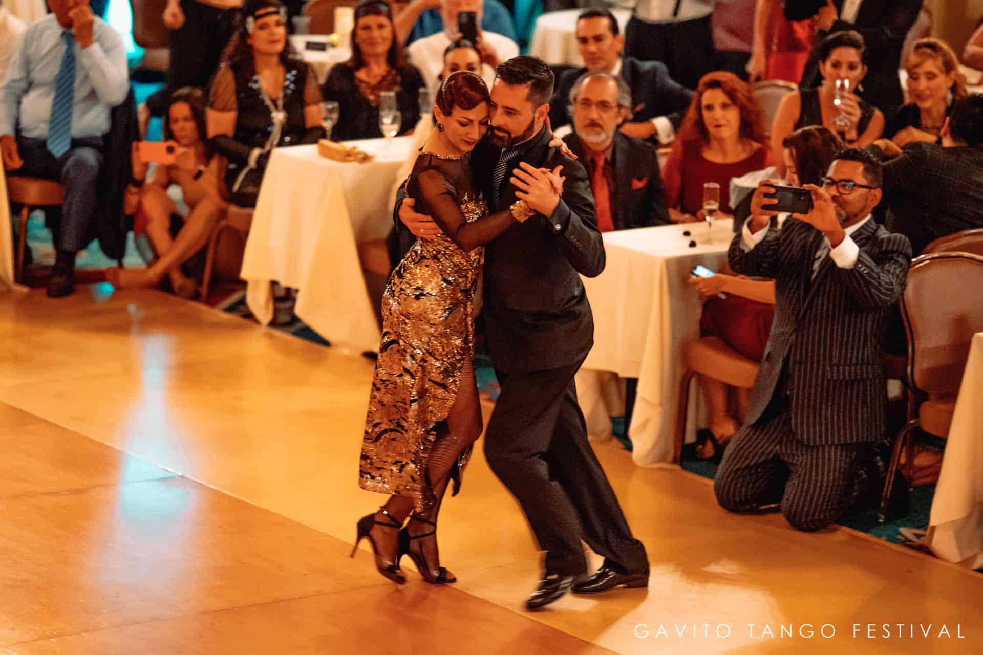 Couple passionately dancing tango in a lively setting.
