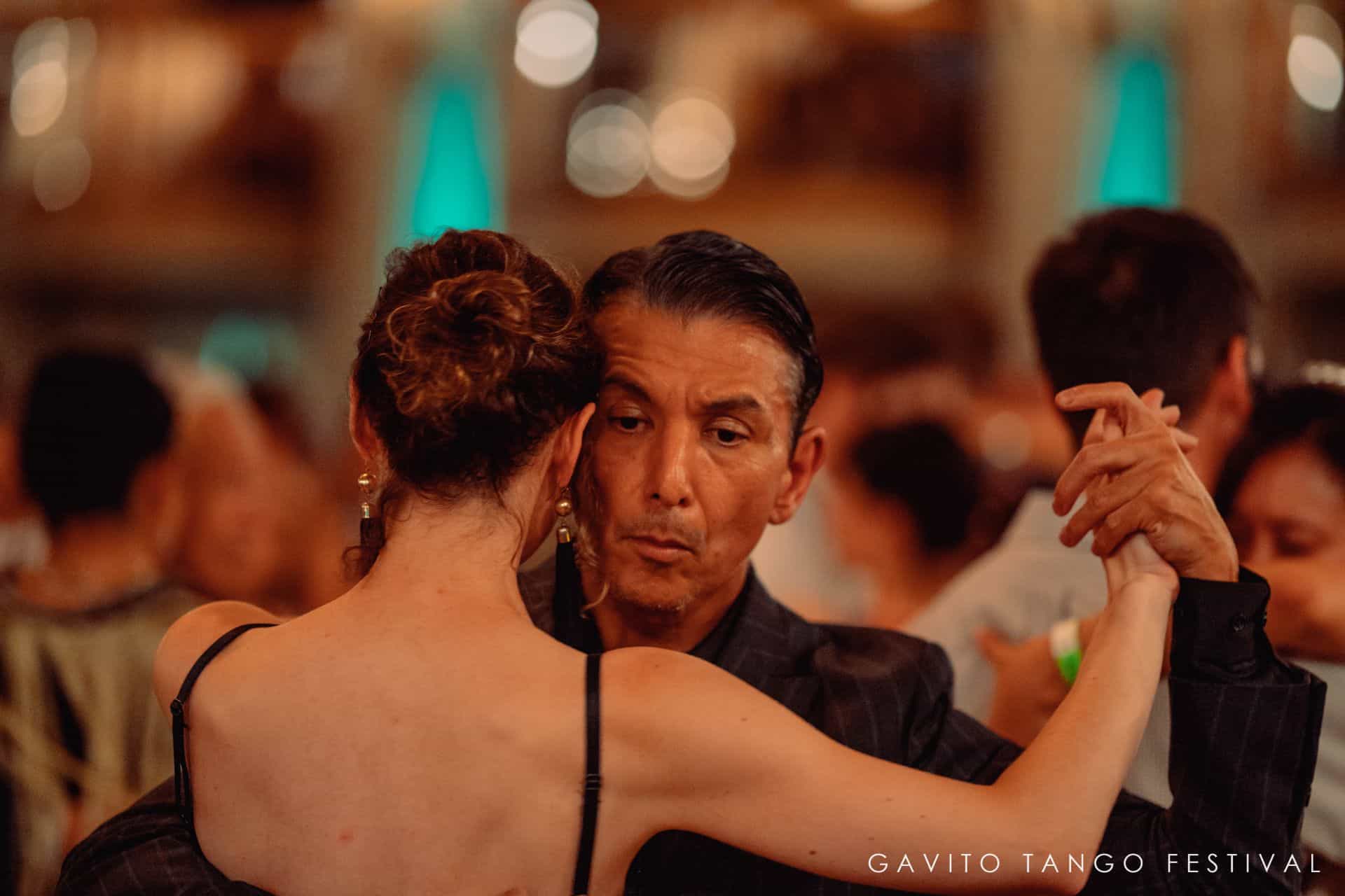 Couple dancing closely in a lively setting.