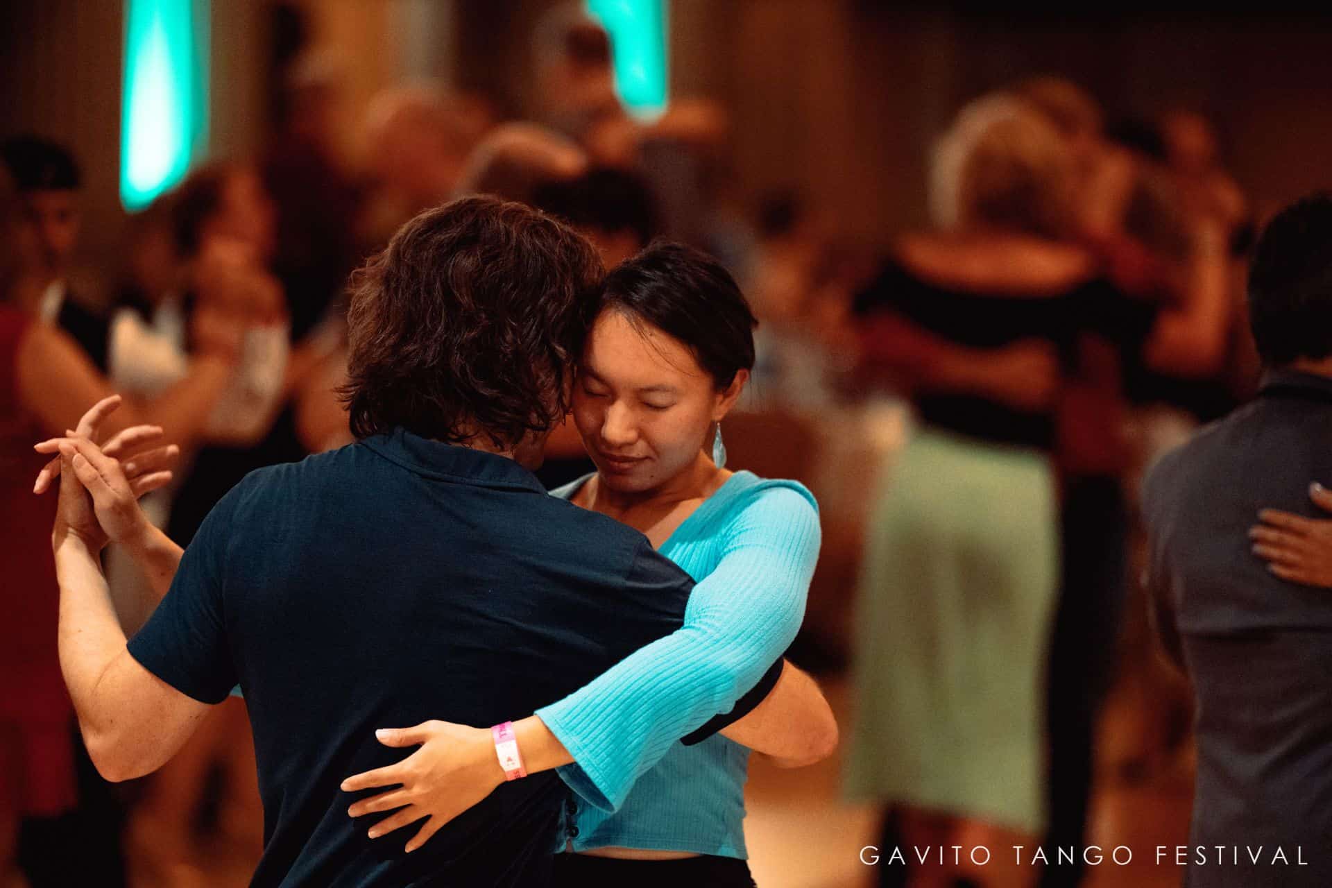 A couple dancing closely in a warmly lit room.