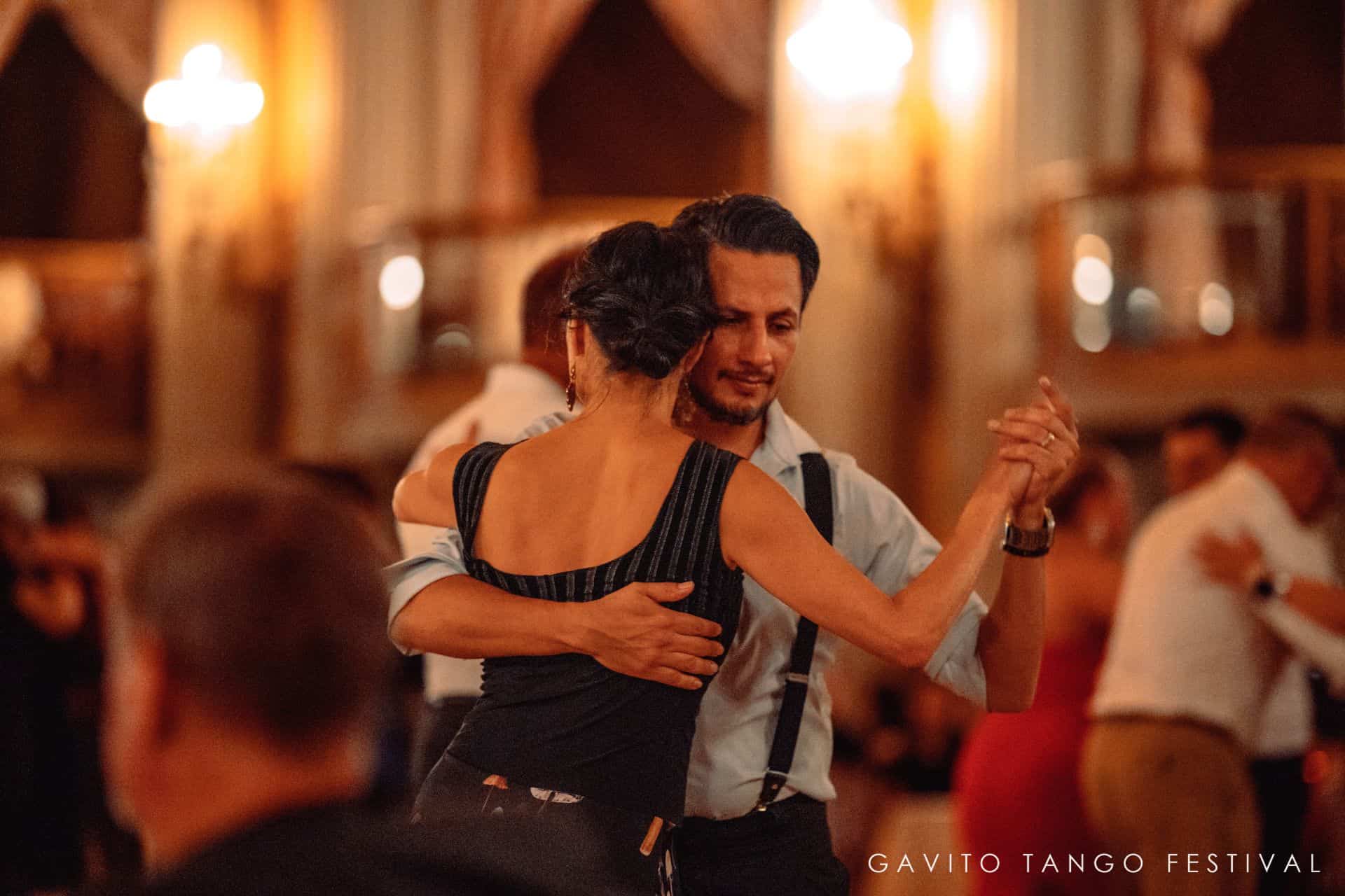 A couple dancing closely in a warmly lit room.