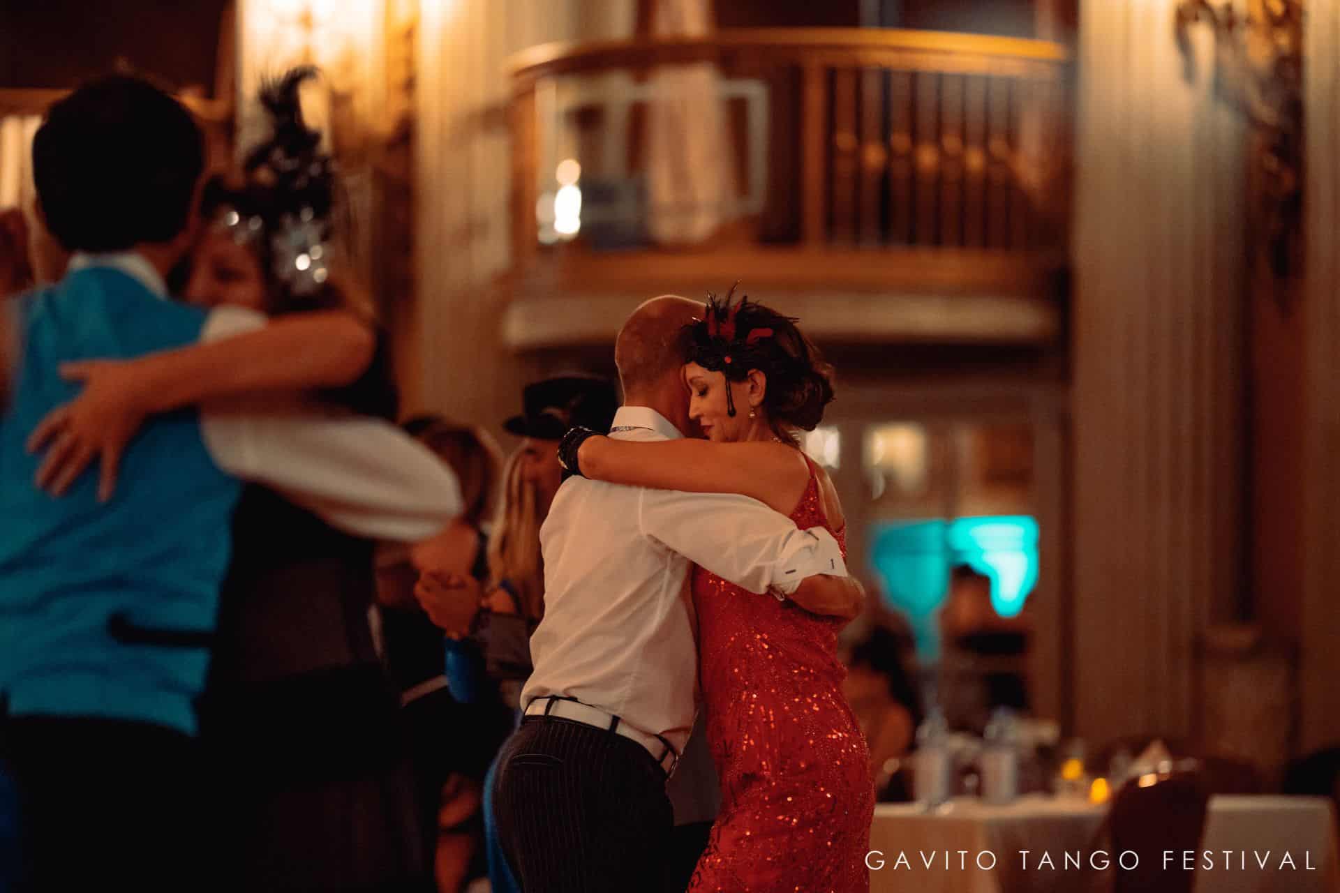 Two people hugging warmly in a cozy, warmly lit room.
