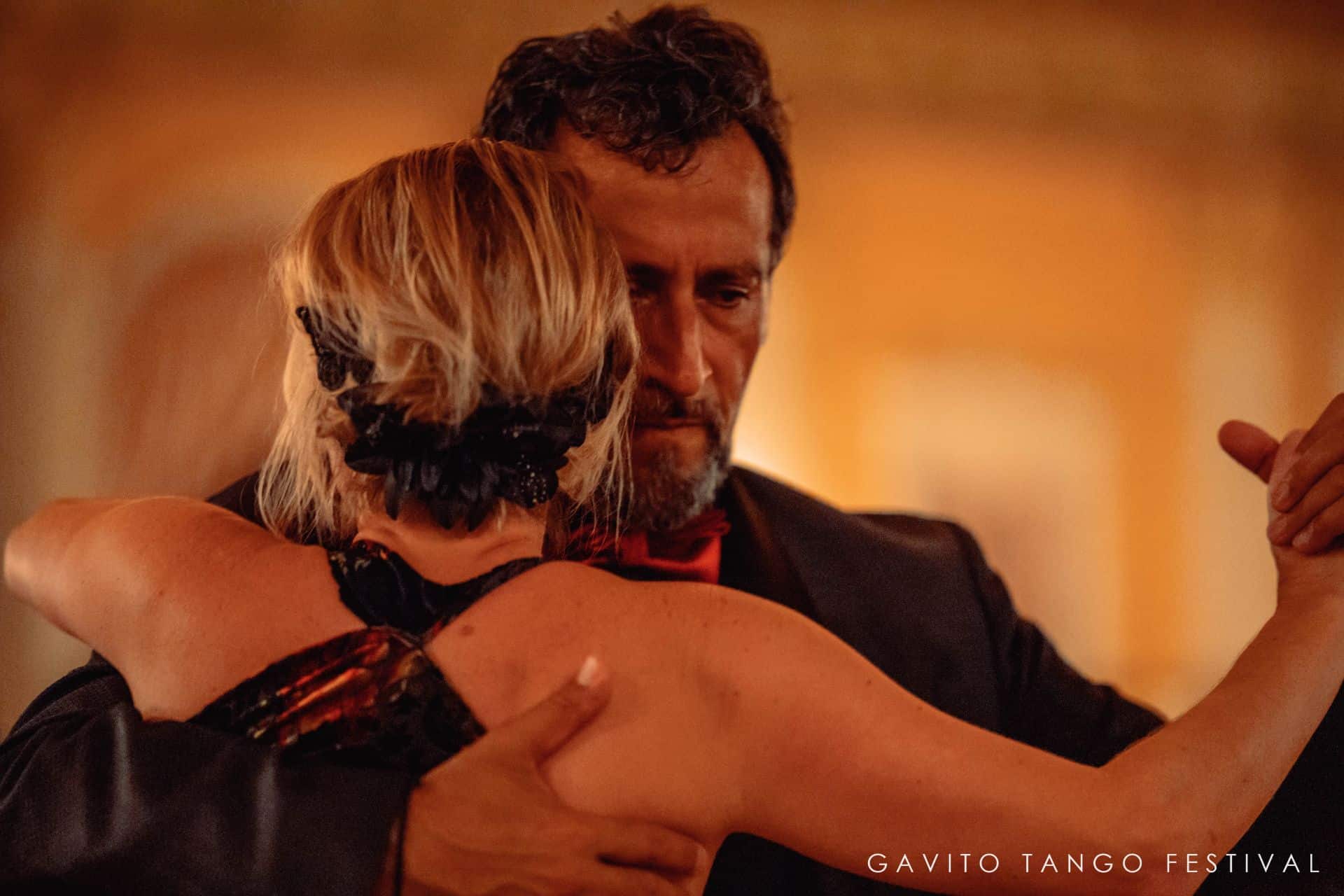 Couple dancing closely in warm, intimate lighting.