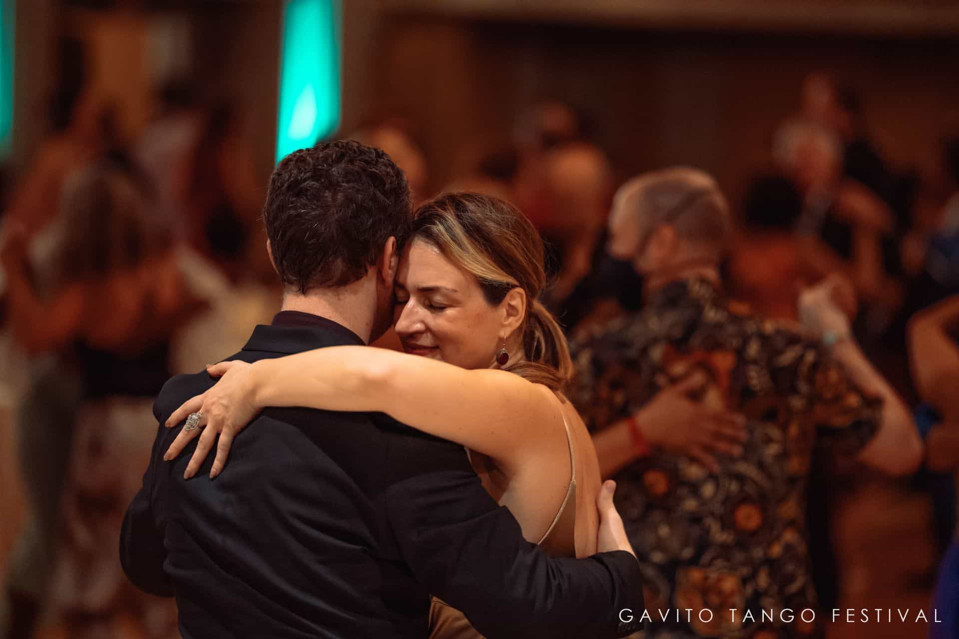 Couple dancing closely at a crowded event.