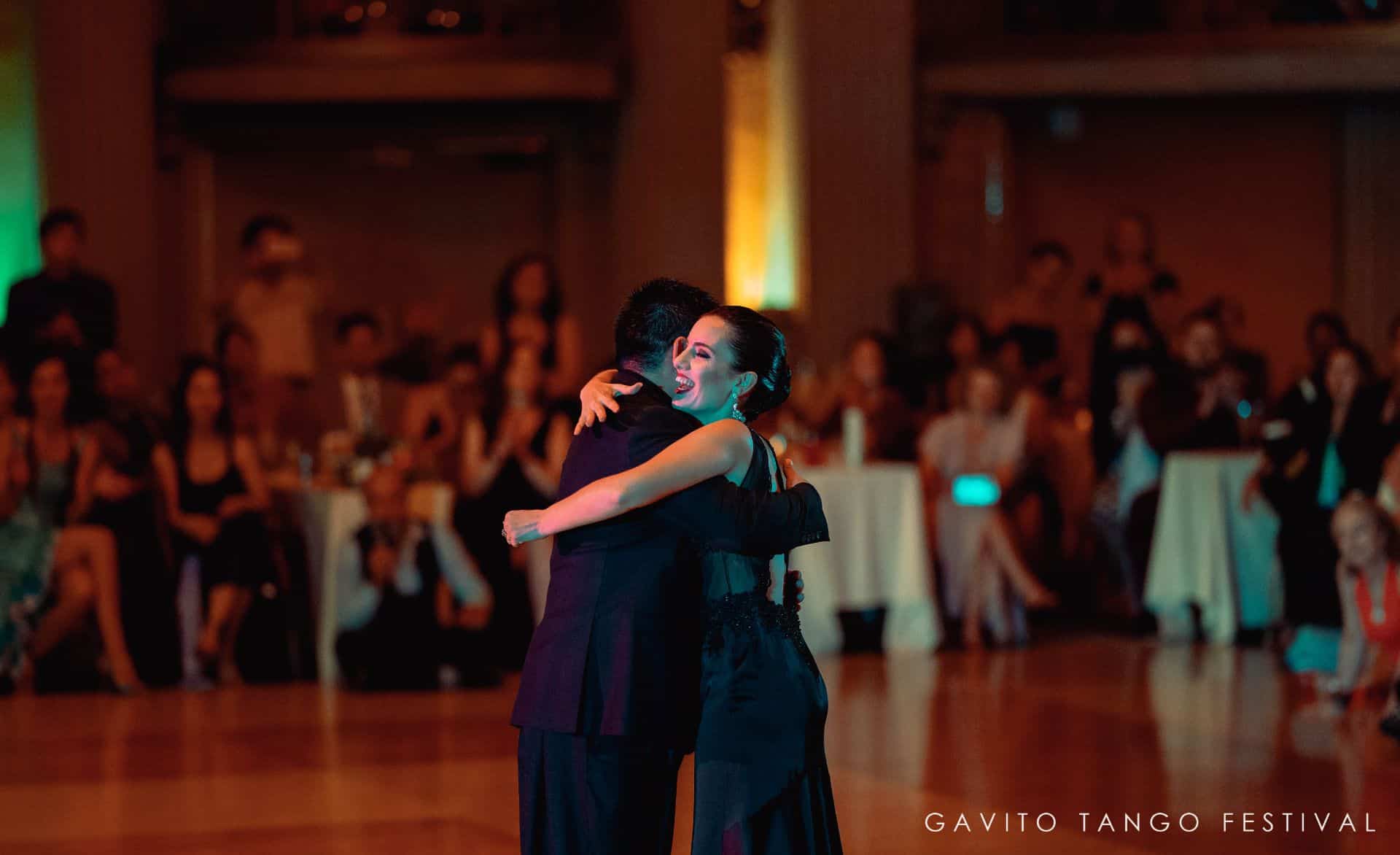 Couple sharing a romantic dance in a warmly lit room.