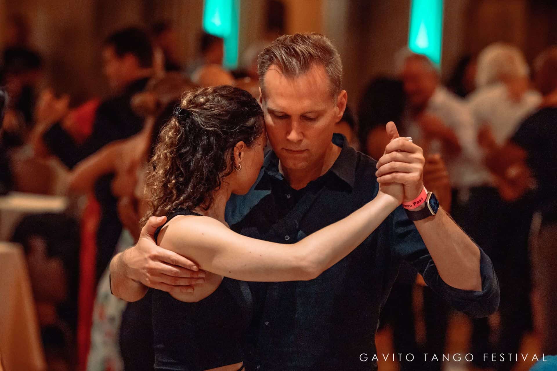 Couple dancing closely in a warmly lit room.