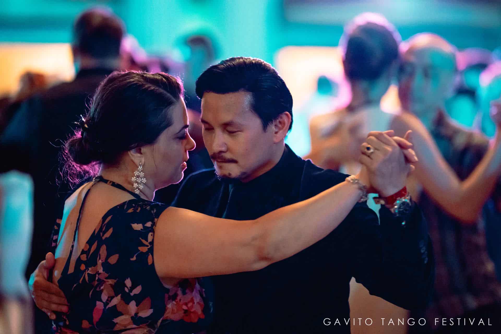 Couple dancing closely in a dimly lit setting.