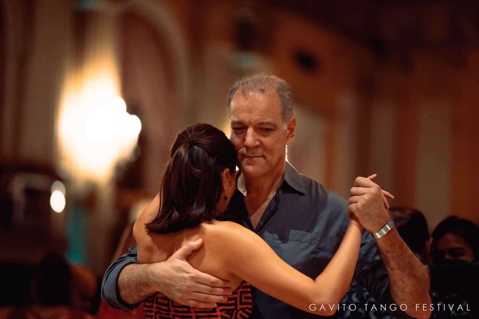 Couple dancing closely in a warmly lit room.
