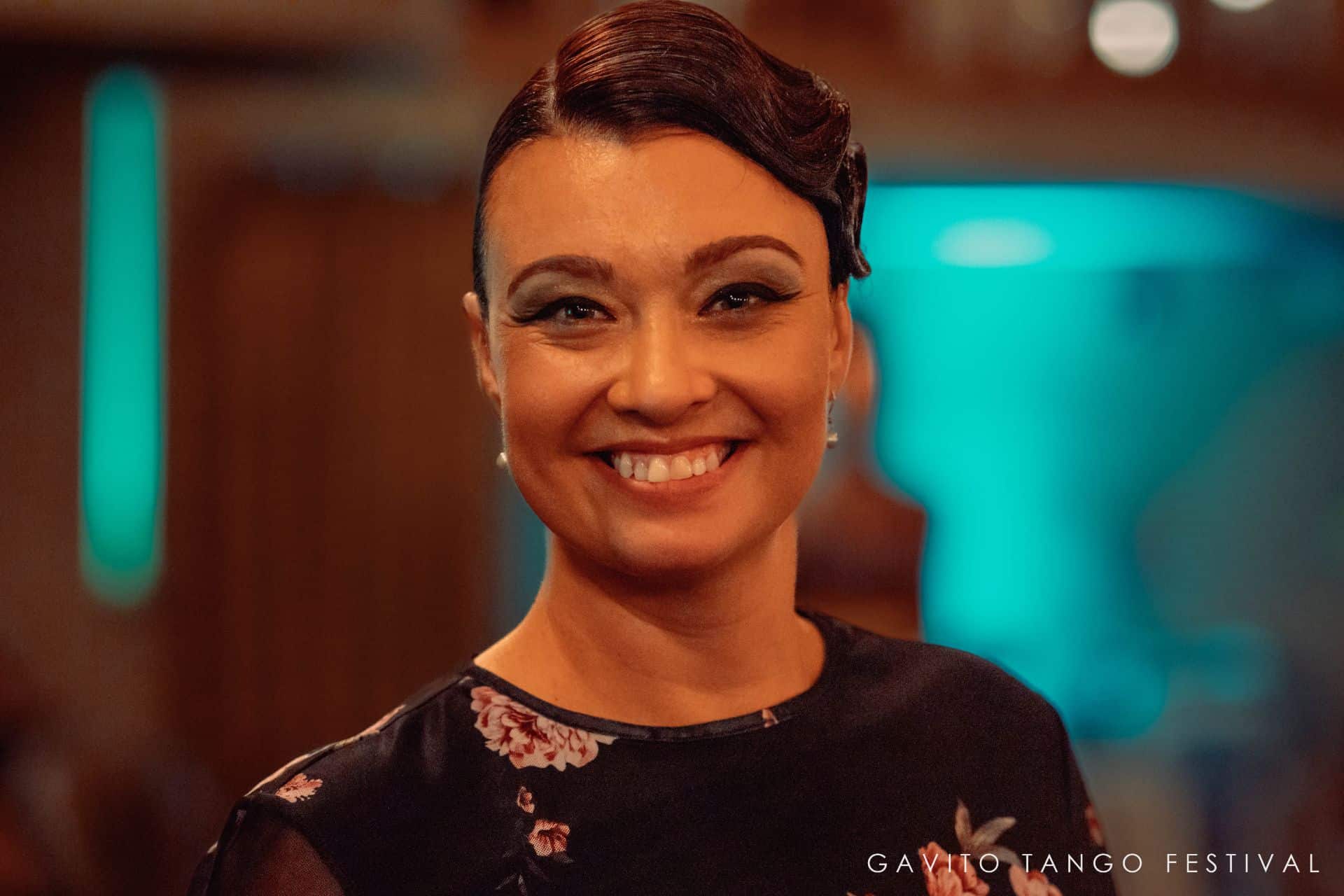 Smiling woman in a warmly lit indoor setting.