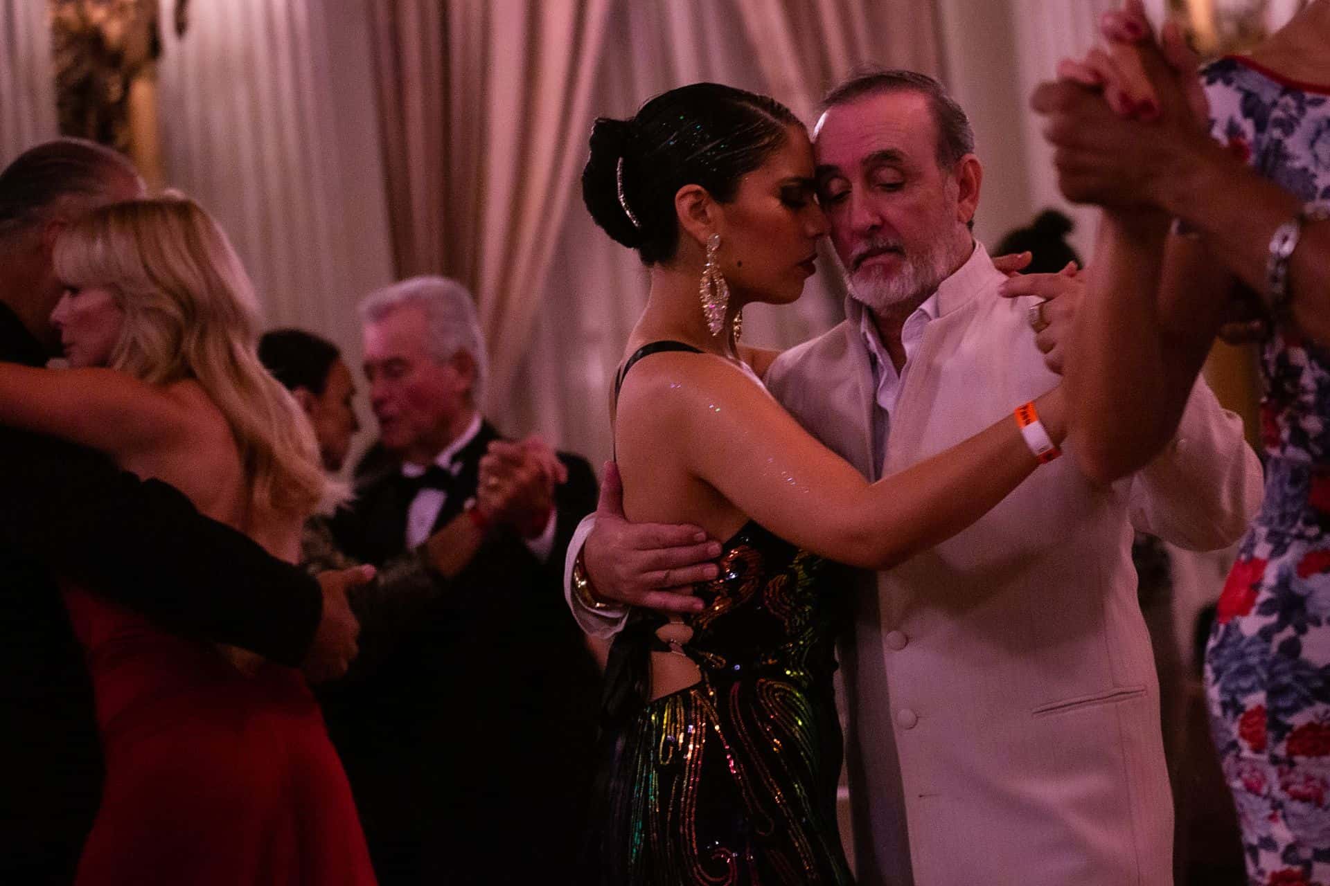 Couple dancing intimately at a lively party.
