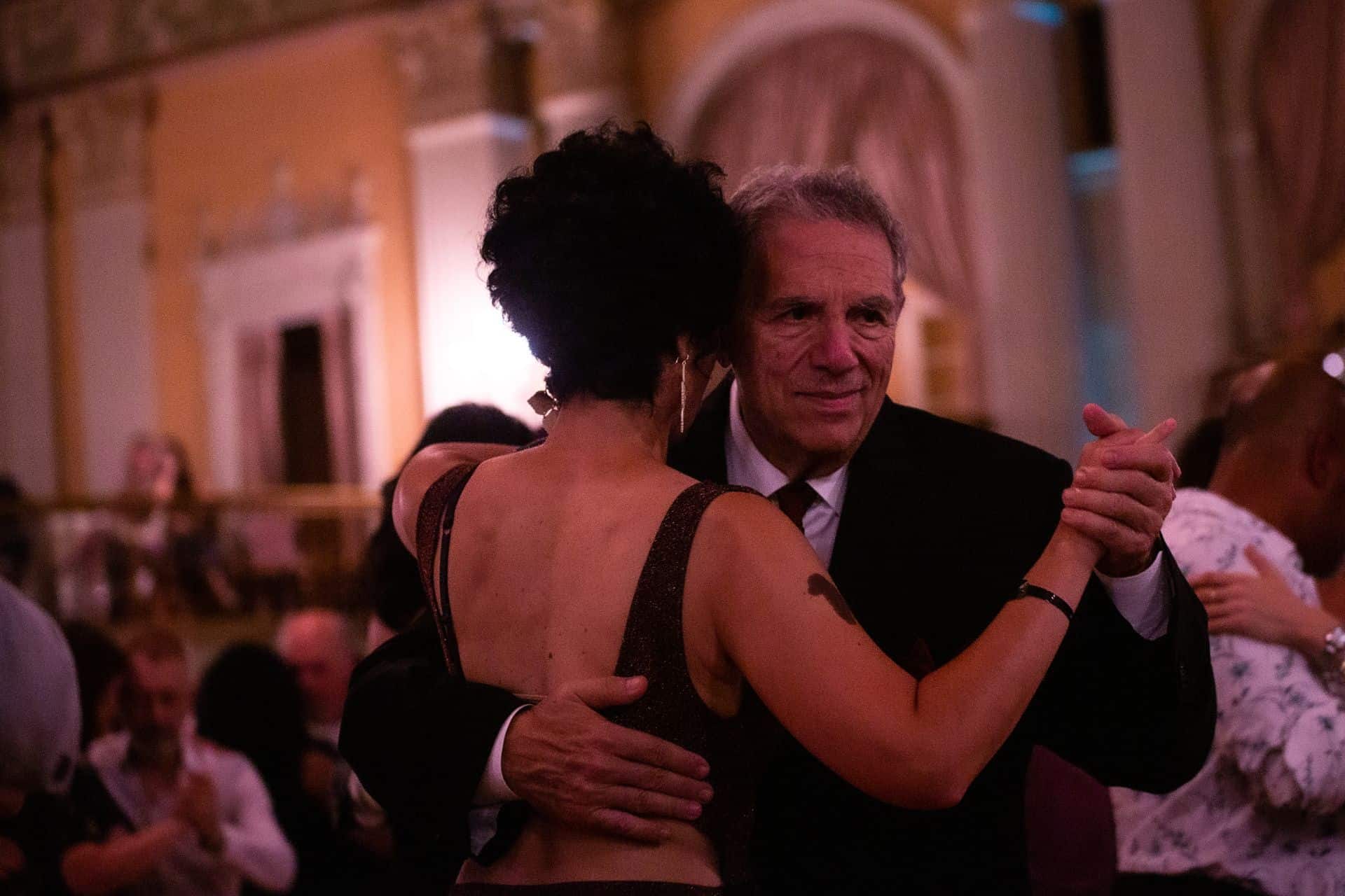 Couple dancing closely in a warmly lit room.