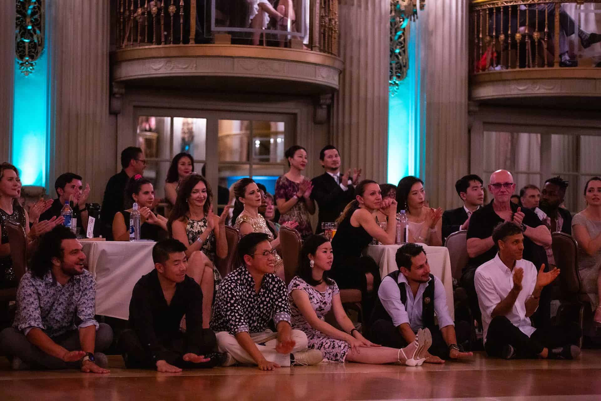 Audience attentively watching a presentation or performance in a large hall.