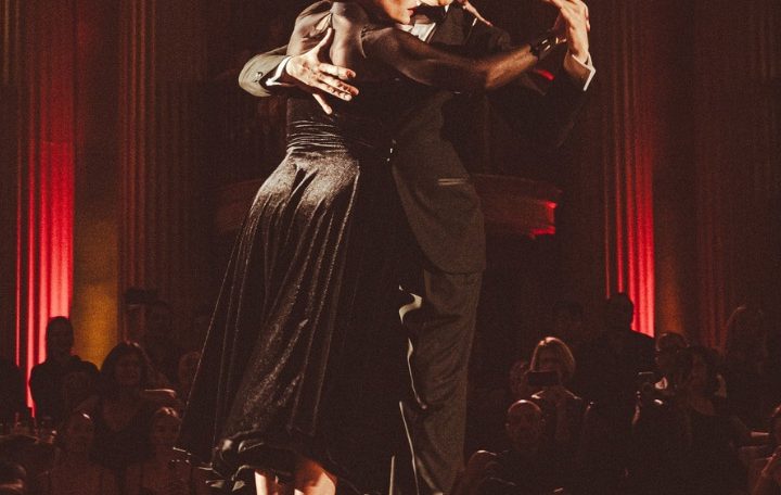 Couple dancing passionately in a dimly lit room.