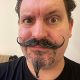 Man with a unique curled mustache and goatee.