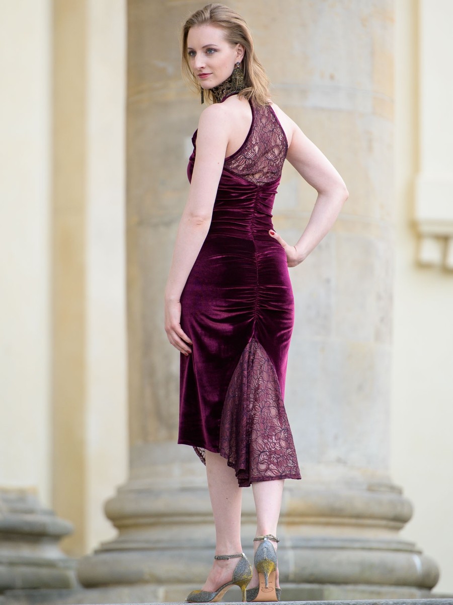 Woman posing in an elegant velvet dress in a classic interior.