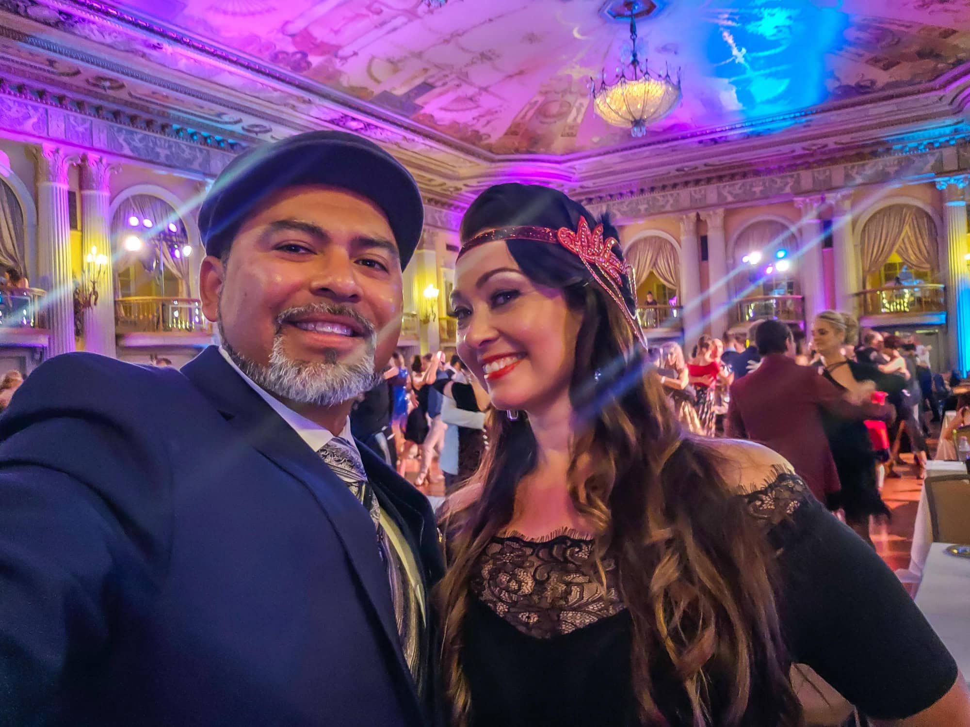 A man and woman smiling at a colorful party.