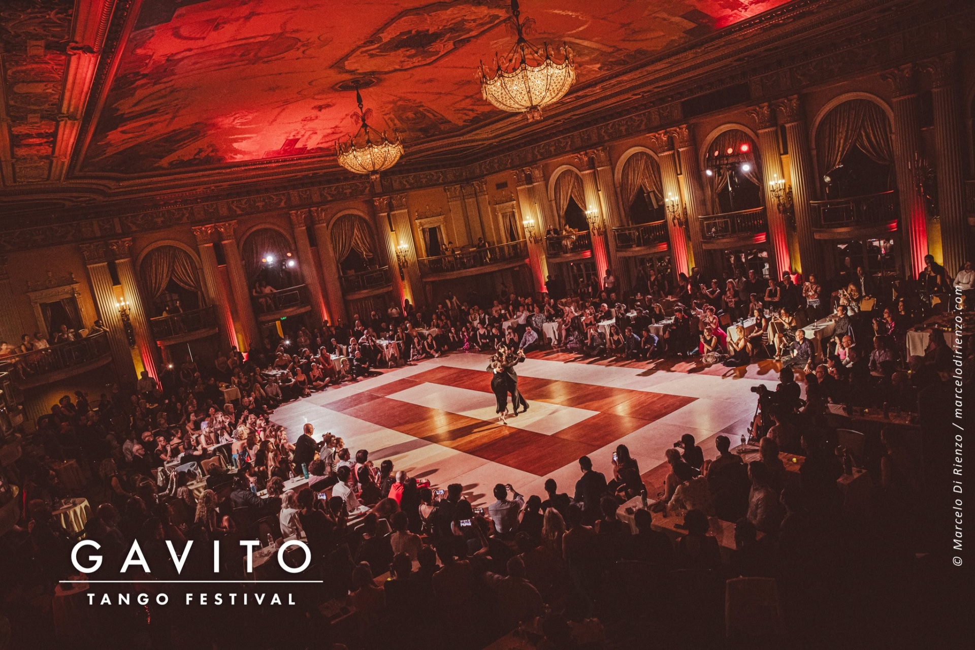 Elegant ballroom wedding with guests seated around a grand dance floor.