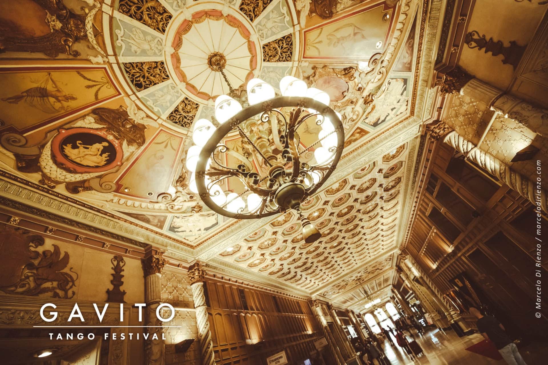 Opulent chandelier in a lavish, ornate ceiling setting.