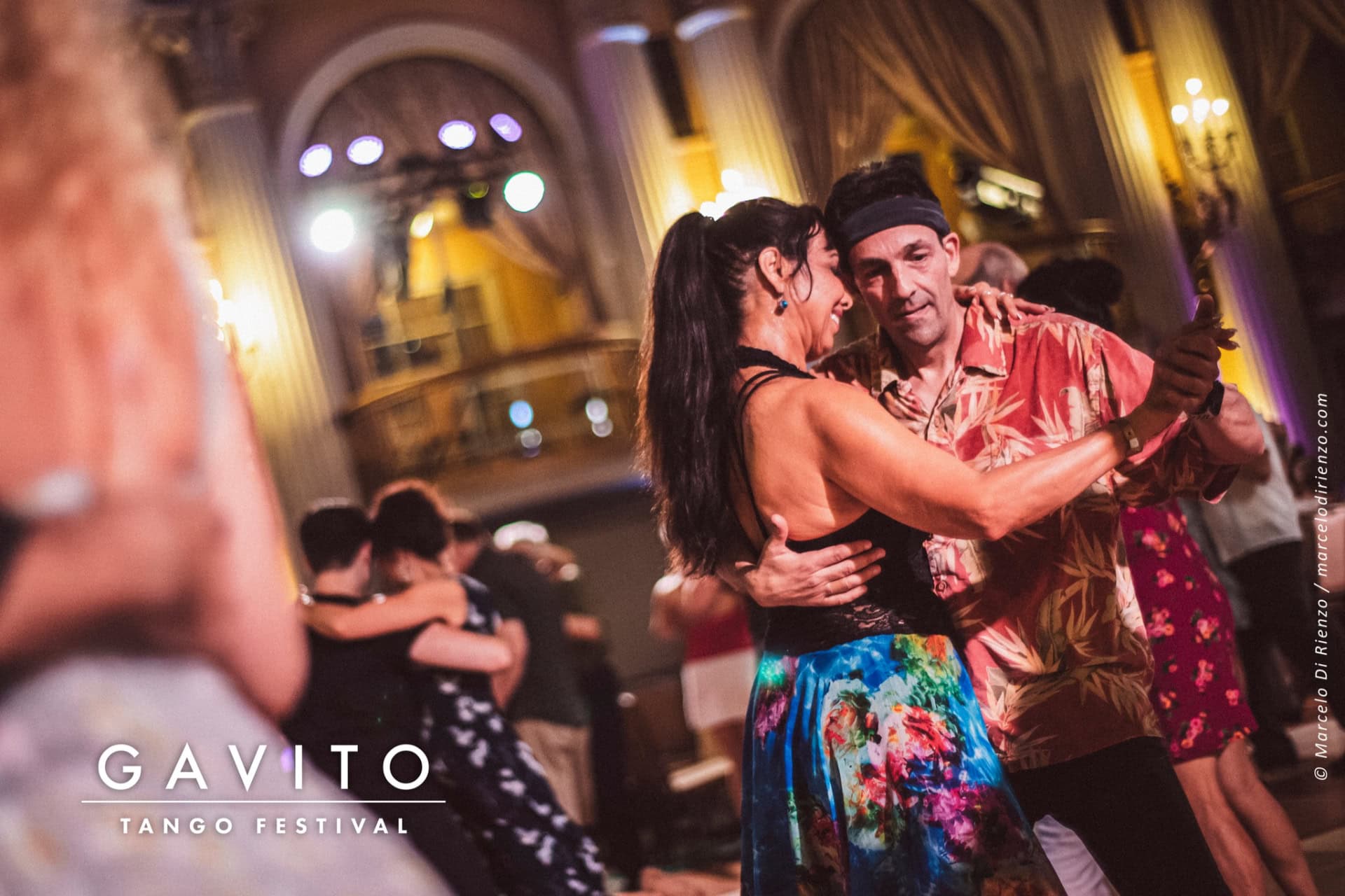 Couple passionately dancing in a lively nightclub setting.