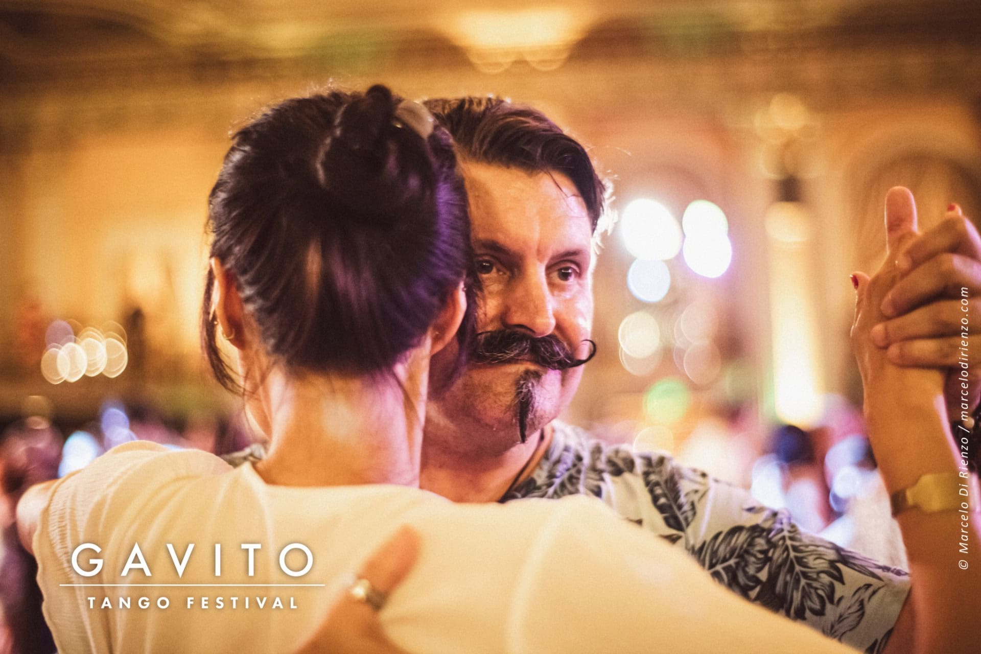 Couple sharing an intimate dance in a warmly lit setting.