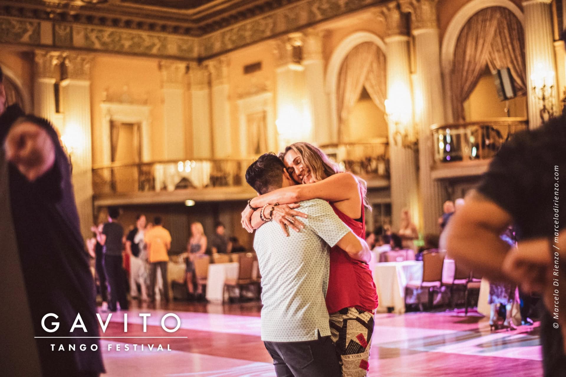 Couple dancing closely in an elegant ballroom setting.