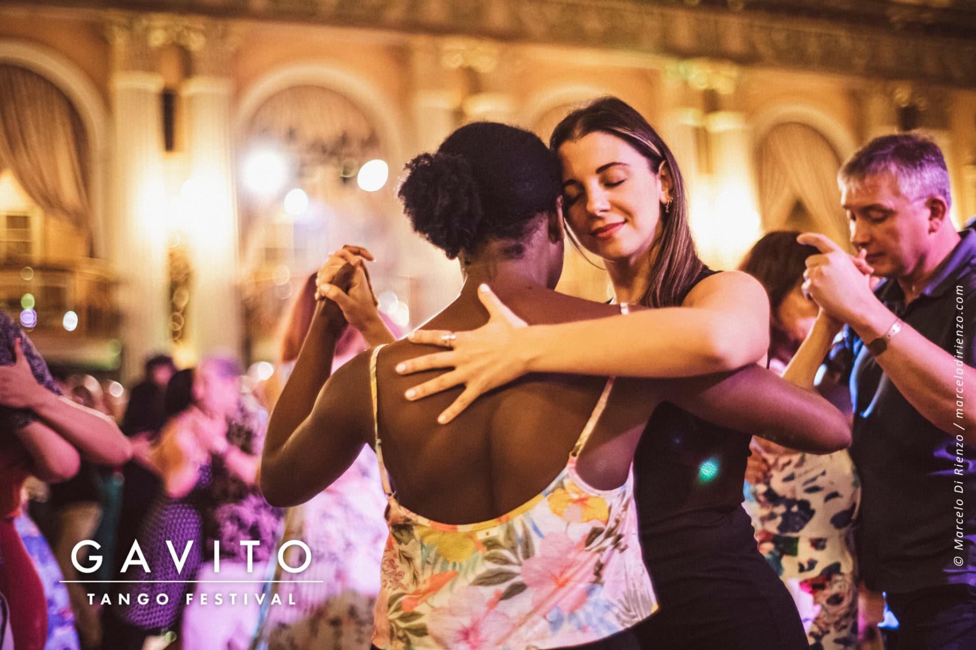 Two women warmly embracing at a festive event.