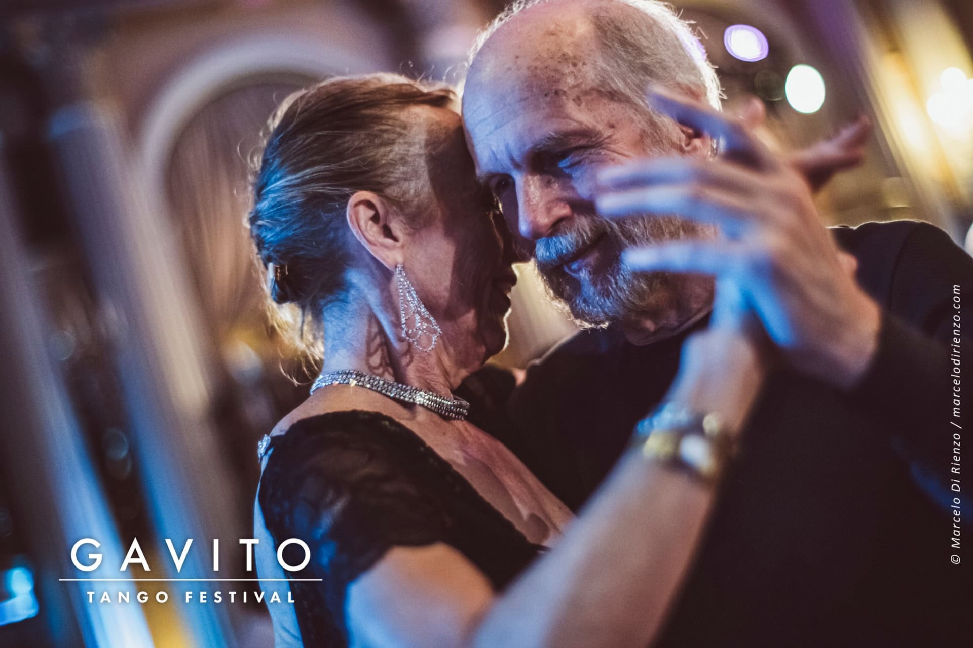 Couple dancing closely at an elegant event.