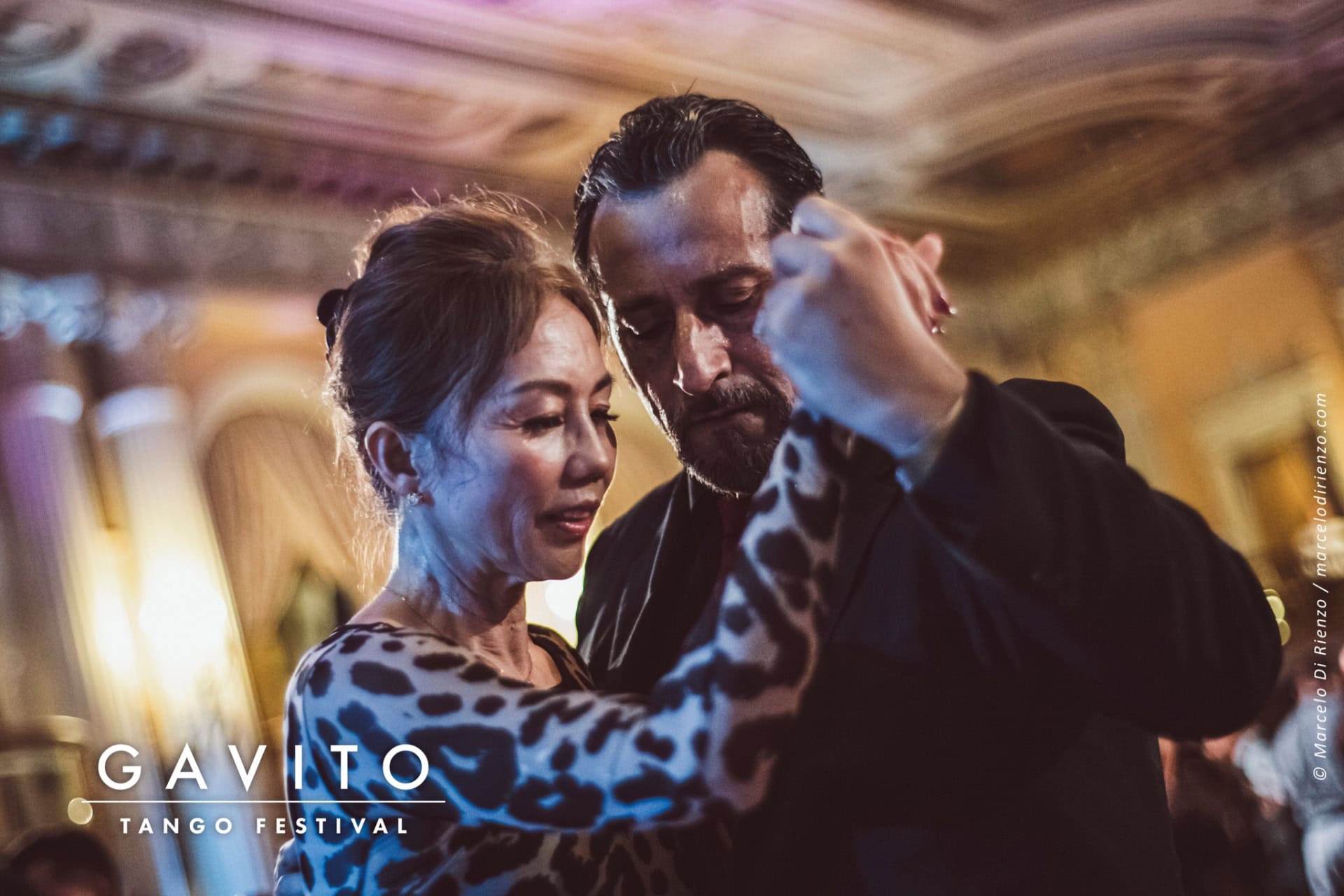 A man and woman dancing closely in a dimly lit setting.