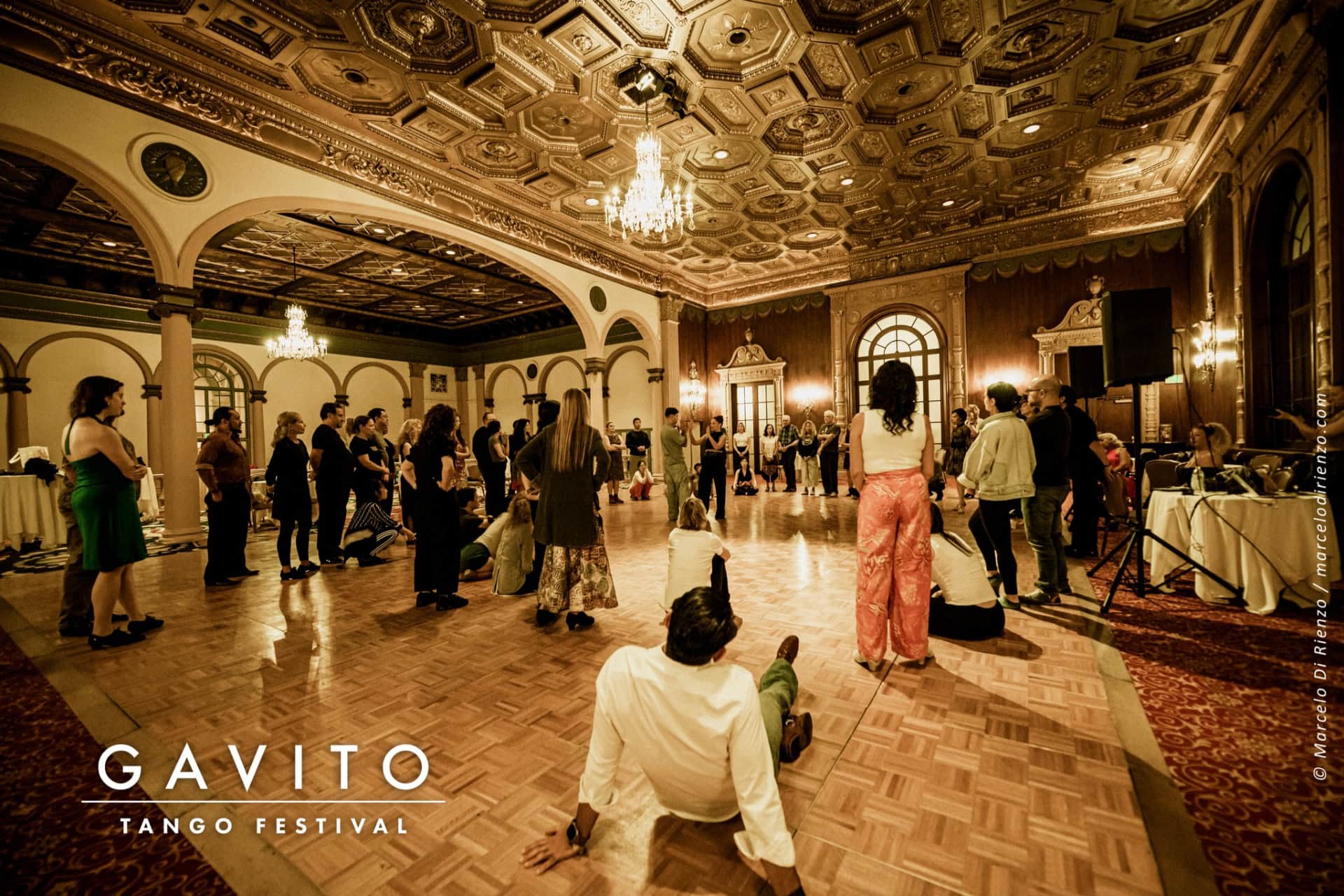 A lively dance festival inside a decorated hall with colorful lights.